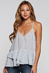 [Color: Natural/Denim] A front facing image of a blonde model wearing a striped tank top with a relaxed fit, v-neckline, racerback, and a layered ruffled hem. 
