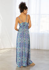 [Color: Blue/Mint] A back facing image of a brunette model wearing a blue bohemian printed maxi dress with spaghetti straps, a v neckline, and an empire waist. 