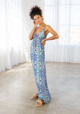 [Color: Blue/Mint] A side facing image of a brunette model wearing a blue bohemian printed maxi dress with spaghetti straps, a v neckline, and an empire waist. 