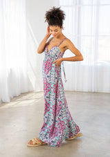 [Color: Coral/Mint] A side facing image of a brunette model wearing a pink and blue bohemian printed maxi dress with spaghetti straps, a v neckline, and an empire waist. 