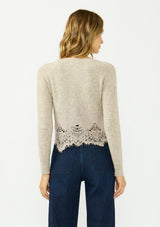 [Color: Heather Oat] A back facing image of a blonde model wearing a beige lace cardigan with a button front. 