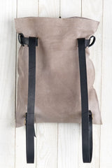 [Color: Sand/Nero] A light grey suede pouch backpack with an adjustable belt closure and leather shoulder straps. 