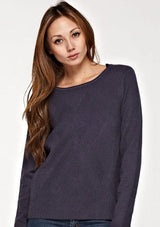 [Color: Graphite] A front facing image of a brunette model wearing a cozy ribbed knit sweater with a geometric design and a round neckline. 