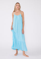 [Color: Aqua] A front facing image of a blonde model wearing an aqua blue bohemian sleeveless maxi dress. With spaghetti straps, a scoop neckline, side pockets, a long flowy tiered skirt, and a sheer lace racerback detail.