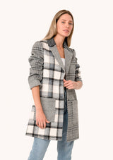 [Color: Taupe/Grey] A front facing image of a blonde model wearing a bohemian long blazer coat in a grey patchwork plaid. With long sleeves, a notched lapel, a button front, and patch side pockets. 