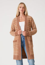 [Color: Taupe/Mustard] A front facing image of a blonde model wearing a fuzzy sweater coat in a brown plaid design. With long sleeves, an open front, a mid length hemline, and side patch pockets. 