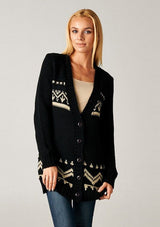 [Color: Black/Tan] A blonde model wearing a black and beige button front cardigan with a southwestern design, long sleeves, deep v-neckline, and ribbed trim. 