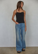 [Color: Black] A front facing image of a brunette model wearing a black jersey cami with a ruched bust and spaghetti straps. 