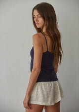 [Color: Navy] A back facing image of a brunette model wearing a navy jersey cami with a ruched bust and spaghetti straps. 