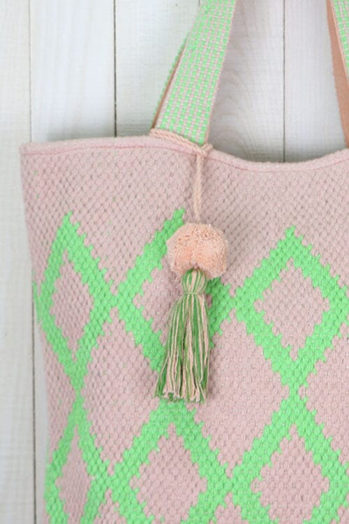 [Color: Petal/Lime] An off white tote bag with a bright green geometric pattern. Features top handles for the shoulder and a playful tassel pom detail. 