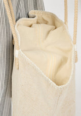 [Color: White/Natural] A detail image of a bohemian tote bag in a light beige texture. With stitched detail throughout, two rope handles, and a top zip closure.