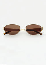 [Color: Brown] Thin gold metal sunglasses with an oval shape and dark tan lenses. Made by FREYRS