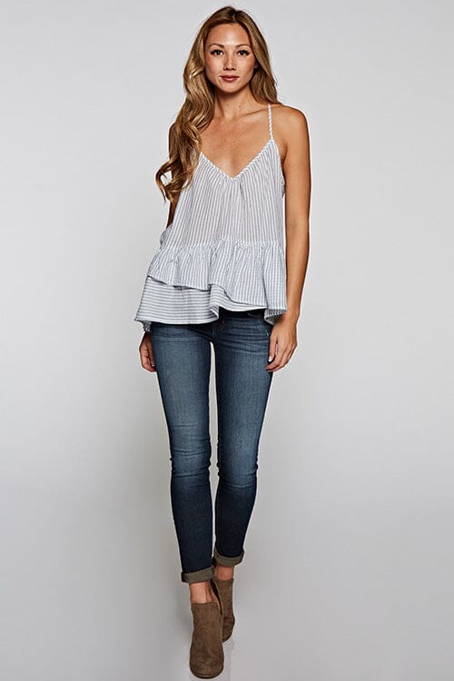 [Color: Natural/Denim] A front facing image of a blonde model wearing a striped tank top with a relaxed fit, v-neckline, racerback, and a layered ruffled hem. 