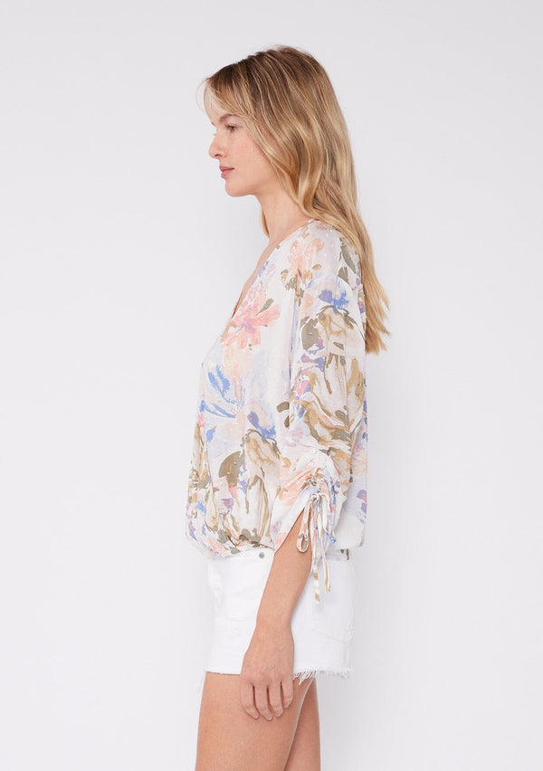 [Color: Off White/Periwinkle] Women's floral summer blouse with a surplice v neckline, front hook and eye closure, ruched three quarter sleeves, and front elastic hem for comfort. A casual floral top paired with white shorts for vacation.