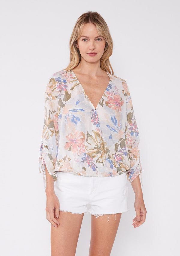 [Color: Off White/Periwinkle] Women's floral summer blouse with a surplice v neckline, front hook and eye closure, ruched three quarter sleeves, and front elastic hem for comfort. A casual floral top paired with white shorts for vacation. 