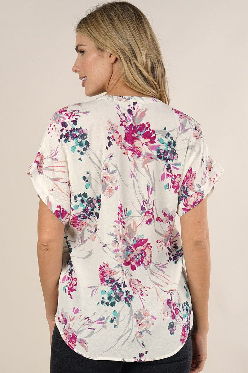 [Color: Ivory/Fuchsia] A back facing image of a blonde model wearing a  cute white and pink button front top with pretty floral print and oversized cuffed sleeves.