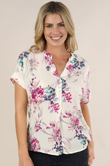 [Color: Ivory/Fuchsia] A front facing image of a blonde model wearing a  cute white and pink button front top with pretty floral print and oversized cuffed sleeves.