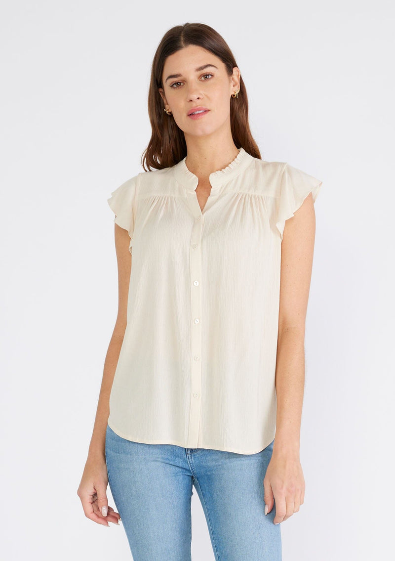 [Color: Natural] A front facing image of a brunette model wearing an off white crinkle gauze short sleeve flutter top with a button front and a ruffled neckline.