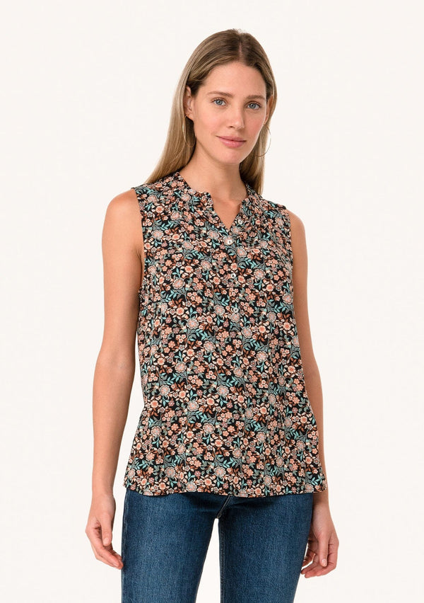 [Color: Black/Teal] A front facing image of a blonde model wearing a transitional fall sleeveless blouse in a black and teal floral print. With a button front, a ruffle trimmed neckline, and a relaxed fit. 