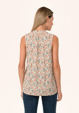 [Color: Cream/Teal] A back facing image of a blonde model wearing a transitional fall sleeveless blouse in a cream and teal floral print. With a button front, a ruffle trimmed neckline, and a relaxed fit. 