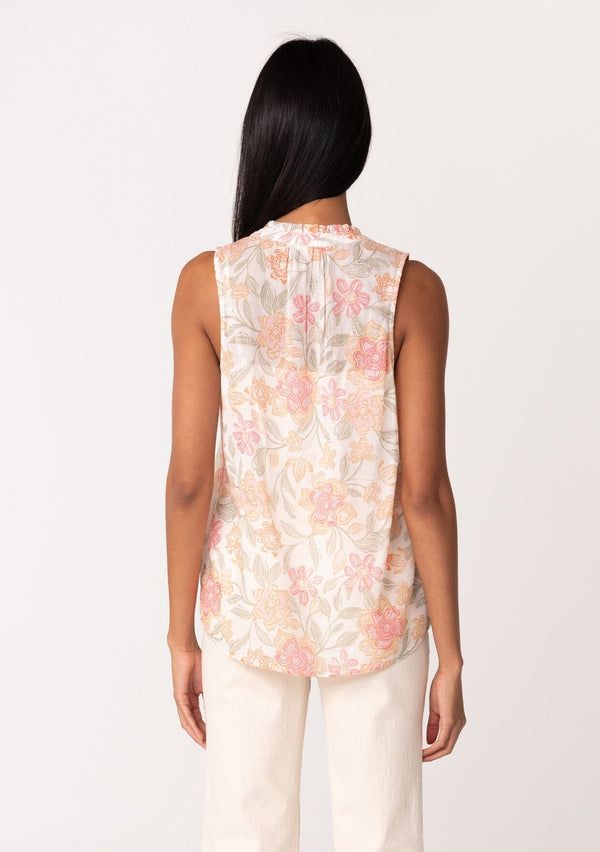 [Color: Natural/Coral] A back facing image of a brunette model wearing a lightweight cotton tank top in a pink floral print. With a ruffled neckline, a button front, and a relaxed fit. 