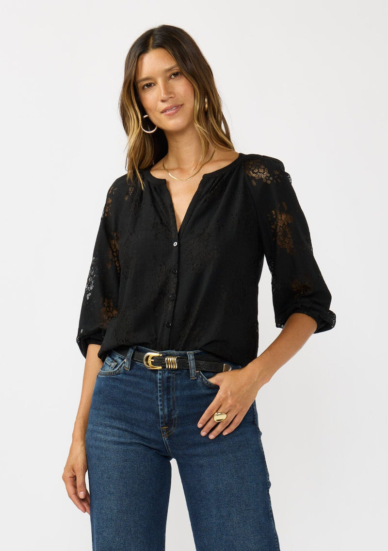 [Color: Black] A front facing image of a brunette model wearing a black lace blouse with a button front, split v-neckline and 3/4 length sleeves. A classic and romantic top for the fall season. 