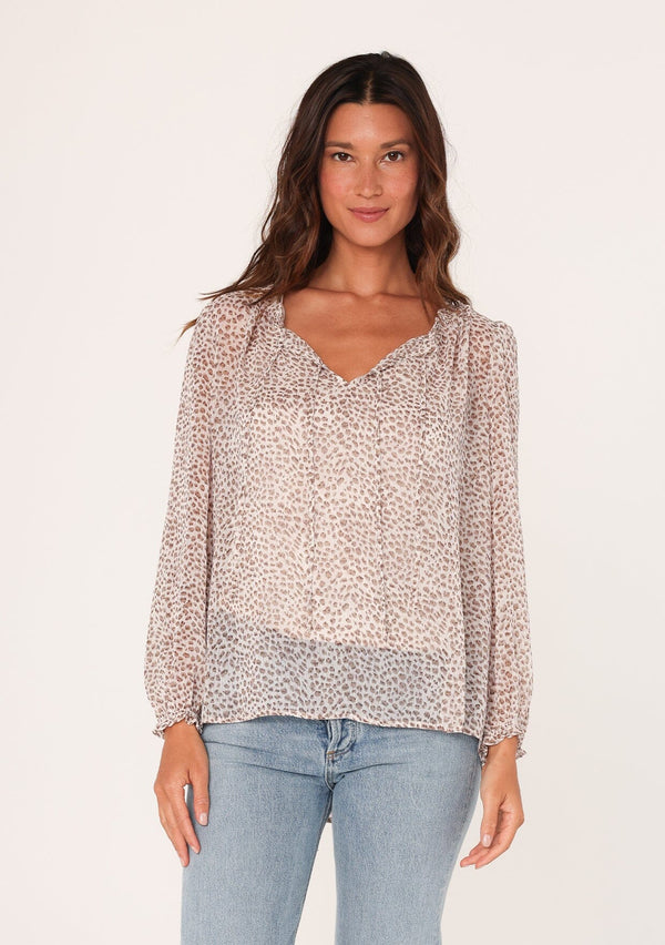 [Color: Ivory/Taupe] A front facing image of a brunette model wearing a sheer chiffon bohemian blouse in an ivory and brown animal print. With long sleeves, an elastic wrist cuff, and a split v neckline with double ties. 