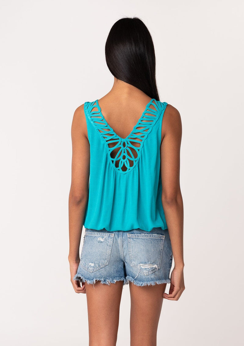 [Color: Turquoise] A back facing image of a brunette model wearing a casual turquoise blue bohemian summer tank top with a surplice v neckline, an elastic waist, and a back soutache braided detail. 