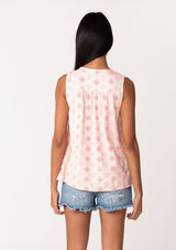 [Color: Natural/Pink] A back facing image of a brunette model wearing a classic sleeveless bohemian blouse in pink embroidery. With a split v neckline and tassel ties. Made with one hundred percent cotton. 