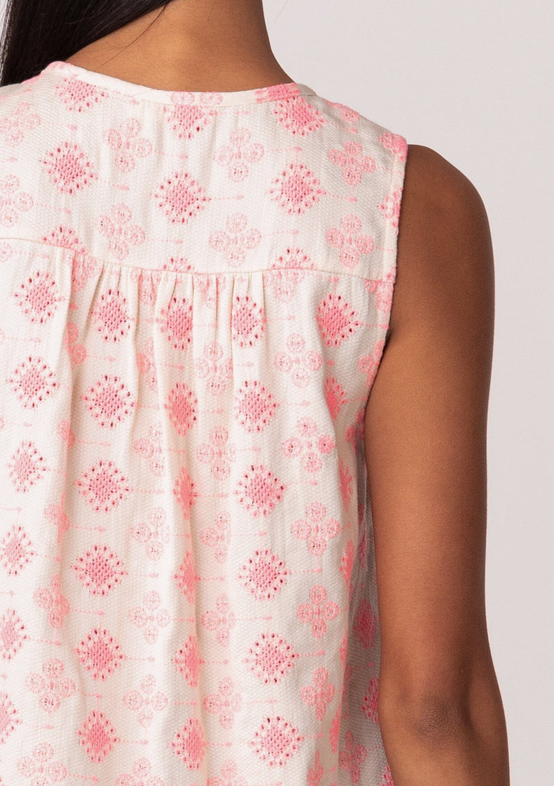 [Color: Natural/Pink] A close up back facing image of a brunette model wearing a classic sleeveless bohemian blouse in pink embroidery. With a split v neckline and tassel ties. Made with one hundred percent cotton. 