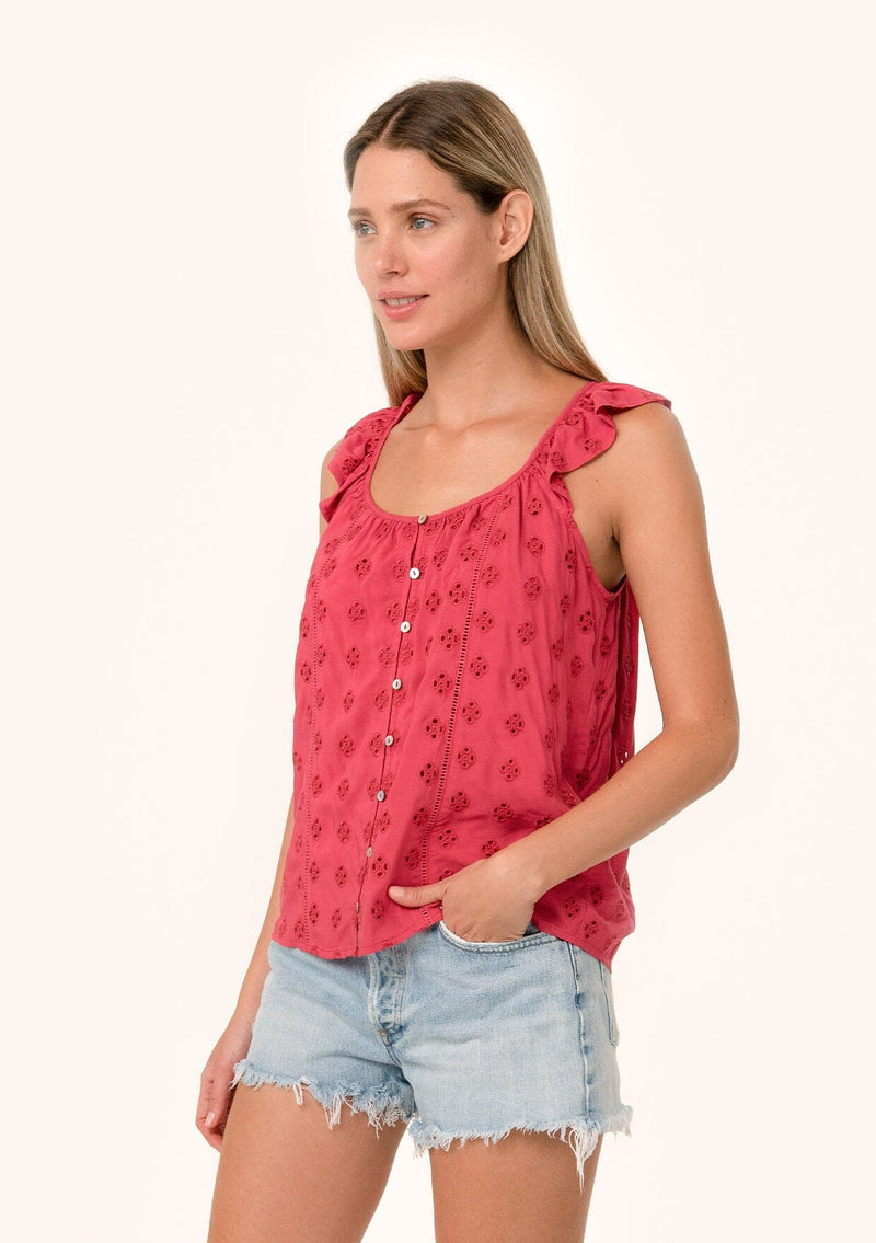 [Color: Fuchsia] An angled side facing image of a blonde model wearing a pink summer top with embroidered eyelet details. With a button front, flutter straps, and a scoop neckline.