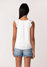 [Color: White] A back facing image of a brunette model wearing a white summer top with embroidered eyelet details. With a button front, flutter straps, and a scoop neckline. 