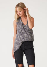 [Color: Grey/Cream] A front facing image of a blonde model wearing a grey printed tank top. With an asymmetric hemline, an exposed side zip closure, a surplice front, and an attached lining with a scoop neckline. 