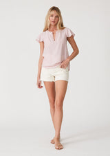 [Color: Dusty Pink] A full body front facing image of a blonde model wearing a lightweight bohemian resort top  in dusty pink. With short flutter sleeves, a split v neckline with embroidered top stitch details, and a relaxed fit. 