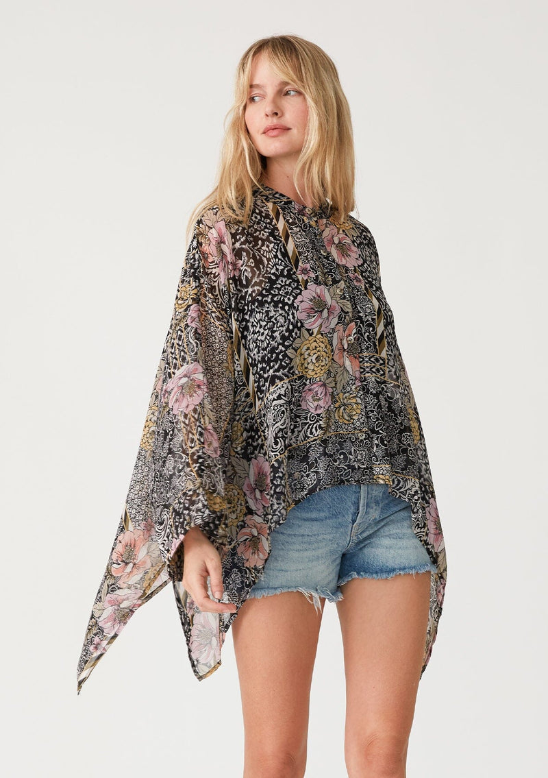 [Color: Black/Dusty Peach] A front facing image of a blonde model wearing an ultra flowy bohemian resort blouse in a black and pink mixed floral print. Crafted from chiffon and featuring long dolman sleeves, a high round neckline, side slits, and a button front. 