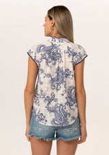 [Color: White/Navy] A back facing image of a blonde model wearing a summer top in a blue and white vintage floral print. With short cap sleeves, a split v neckline with tassel ties, and a contrast crochet edge stitch trim.