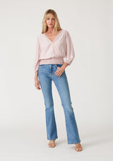 [Color: Dusty Pink] A full body front facing image of a blonde model wearing a dusty pink bohemian resort top with three quarter length sleeves, a surplice v neckline with lace trim, and a smocked elastic waist. 