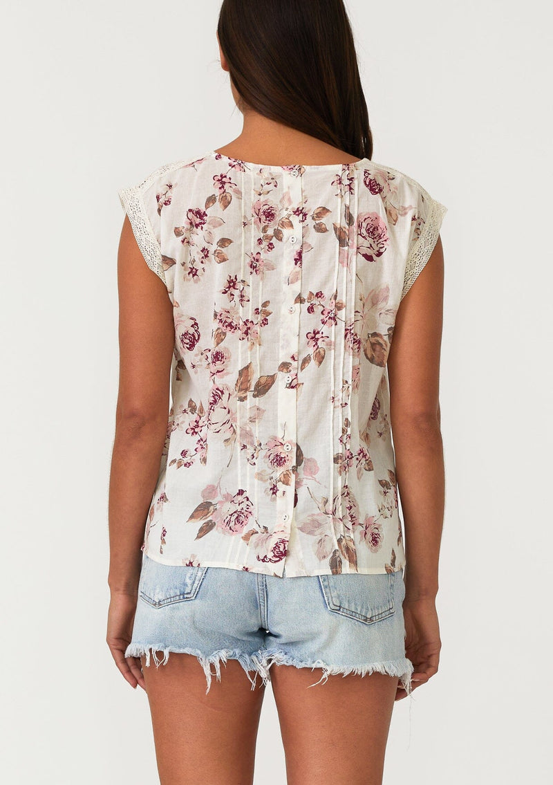 [Color: Natural/Dusty Wine] A back facing image of a brunette model wearing a bohemian resort top in a vintage inspired off white and pink floral print. With a scoop neckline, short cap sleeves, lace trim, pintuck details, and a self covered button up back. 