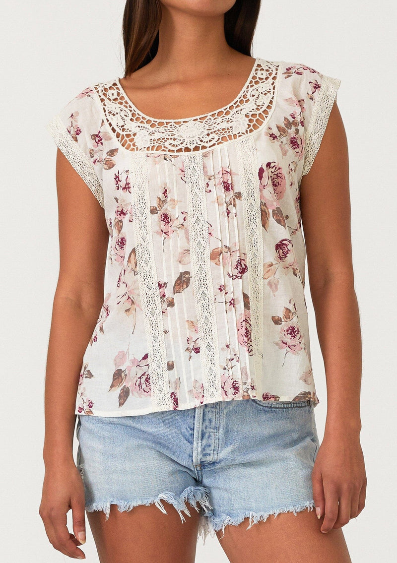 [Color: Natural/Dusty Wine] A close up front facing image of a brunette model wearing a bohemian resort top in a vintage inspired off white and pink floral print. With a scoop neckline, short cap sleeves, lace trim, pintuck details, and a self covered button up back. 