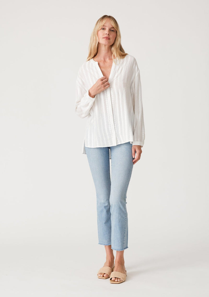 [Color: White] A full body front facing image of a blonde model wearing a bohemian white shirt with embroidered detail. With long sleeves, a v neckline, a button up front, and a relaxed fit. 