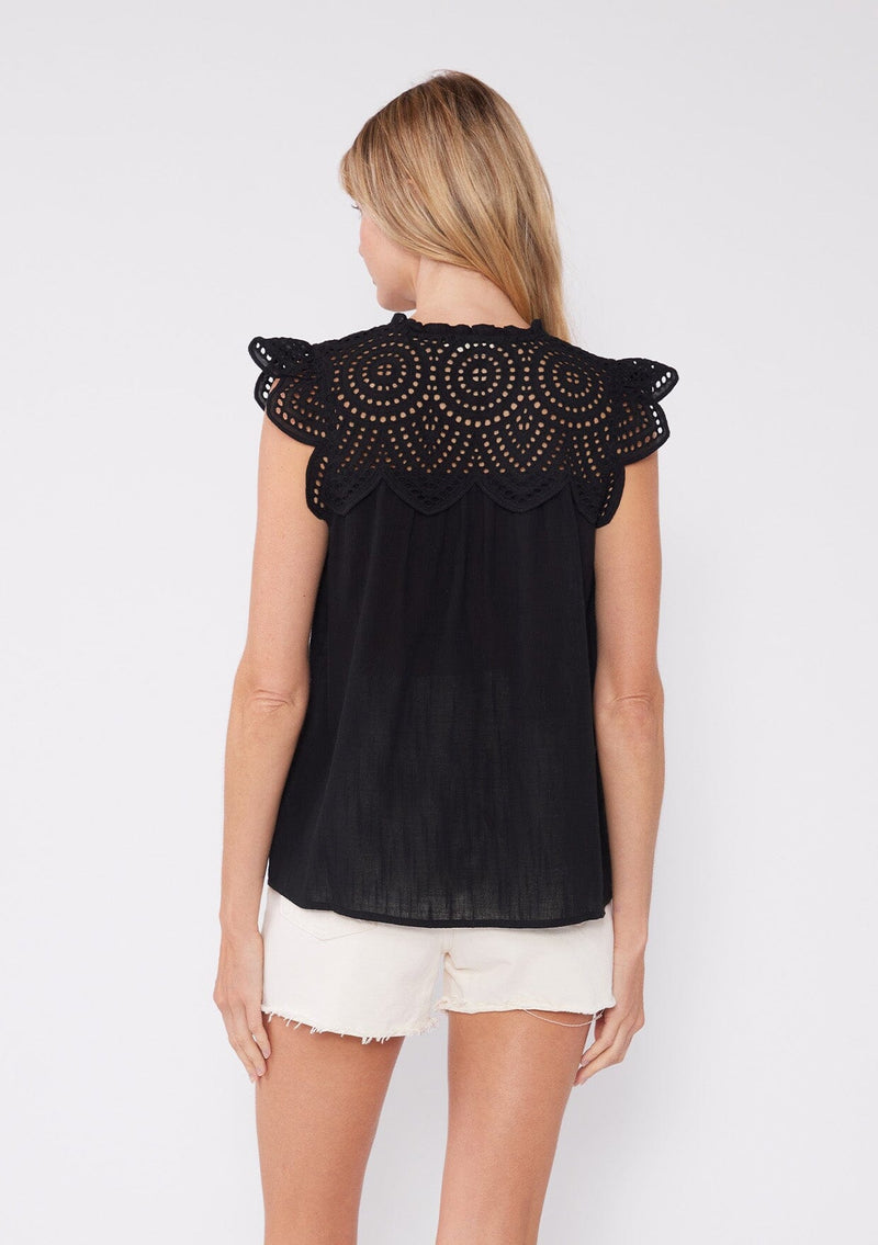 [Color: Black] A front facing image of a brunette model wearing a white bohemian spring top with short cap sleeves, a split v neckline, and an eyelet lace yoke.