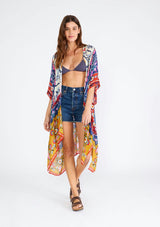 [Color: Natural/Mustard] A front facing image of a brunette model wearing a lightweight bohemian mid length kimono in a mixed floral print. A brightly multi colored style with half length sleeves, an open front, and side slits. Perfect for the beach as a swim cover up or around the house as a lounge robe. 