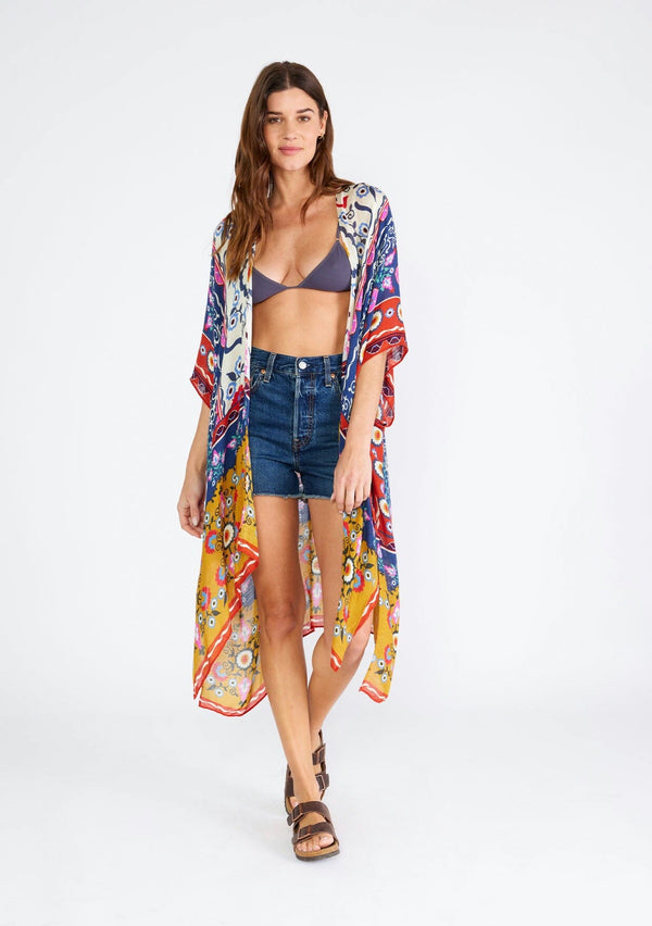 [Color: Natural/Mustard] A front facing image of a brunette model wearing a lightweight bohemian mid length kimono in a mixed floral print. A brightly multi colored style with half length sleeves, an open front, and side slits. Perfect for the beach as a swim cover up or around the house as a lounge robe. 