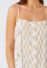 [Color: Latte/Natural] A close up front facing image of a brunette model wearing a pretty camisole tank top designed in an ivory and brown bohemian print. With adjustable spaghetti straps, a scooped neckline, a self covered button front, lattice trim, a relaxed fit, and pintuck details. 