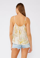 [Color: Dusty Peach/Caramel] A back facing image of a brunette model wearing a bohemian tank top designed in a pink and yellow paisley print. With gold metallic lurex details, adjustable spaghetti straps, a scooped neckline, and a cutout detail at the front. 