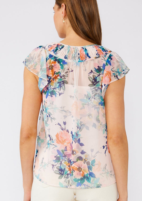 [Color: Peach/Teal] A back facing image of a brunette model wearing a sheer chiffon top in a pink and blue floral print. With short flutter sleeves, a split v neckline with double ties, and pintuck details along the neckline. 
