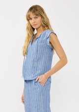 [Color: Blue] A side facing image of a blonde model wearing a blue striped top with a split v neckline, ties, and cap sleeves. Styled with a matching bottom. 