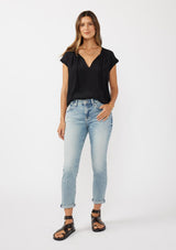 [Color: Black] A brunette model wearing a relaxed fit  black top. With self neck ties, ruched split v neckline, and short dolman sleeves. Styled with a cute vintage denim for a laid back look. 