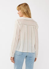 [Color: White/Coral] A back facing image of a blonde model wearing an off white yarn dye stripe top with embroidered eyelet details. This sheer  cotton top features a split v-neckline, long sleeves, button cuff closures, and a tie front hem detail. Perfect for vacation and resort styling. 