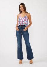 [Color: Natural/Dusty Pink] A front facing image of a brunette model wearing a spring floral cami with a scoop neckline, fixed straps, and a button front. 